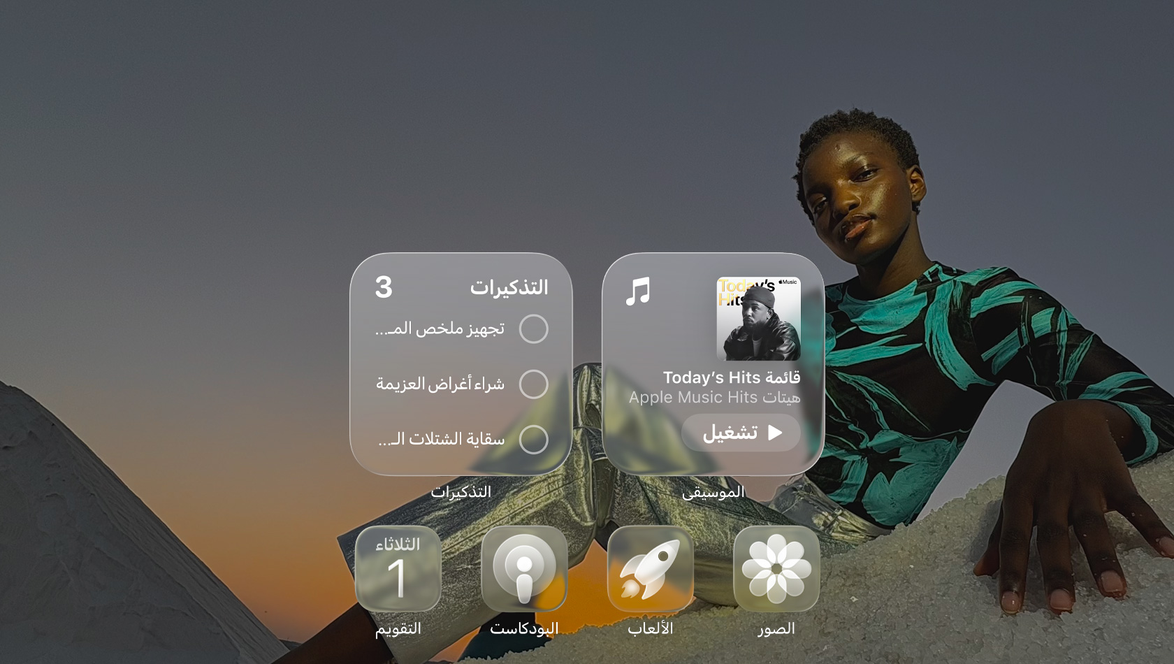 شاشة بتصميم Liquid Glass مع أيقونات شفافة لتطبيقات عدة مثل Apple Music والتذكيرات والصور والألعاب والبودكاست وفيس تايم، وتبدو كلها منعكسة على خلفية الشاشة