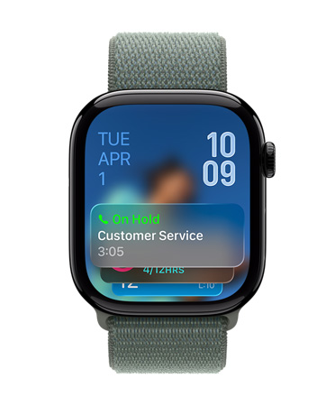 صورة لساعة Apple Watch باللون الأسود اللامع مع حزام باللون الأخضر الرمادي، وتعرض واجهة الساعة إشعار ميزة مساعدة التعليق في الأسفل، والتاريخ في أعلى اليسار، وأرقام الوقت مكدسة في أعلى اليمين